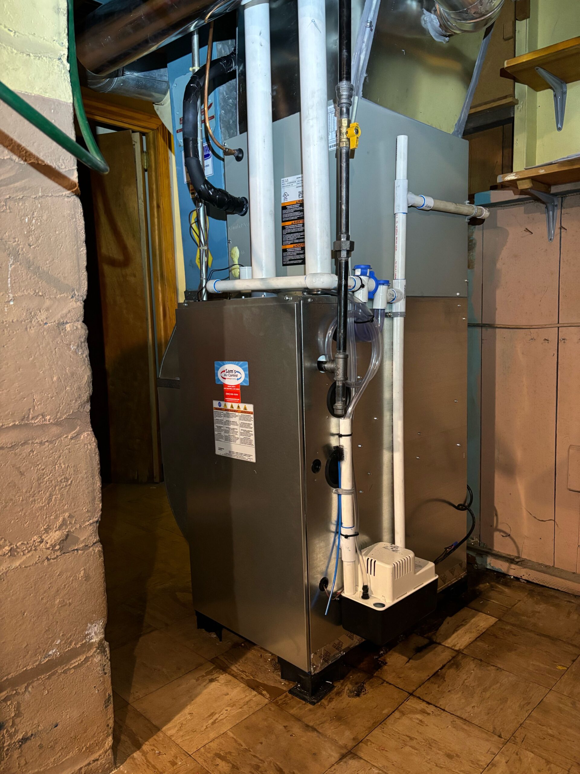 A Sam's Air Control technician servicing an outdoor central Furnace condenser