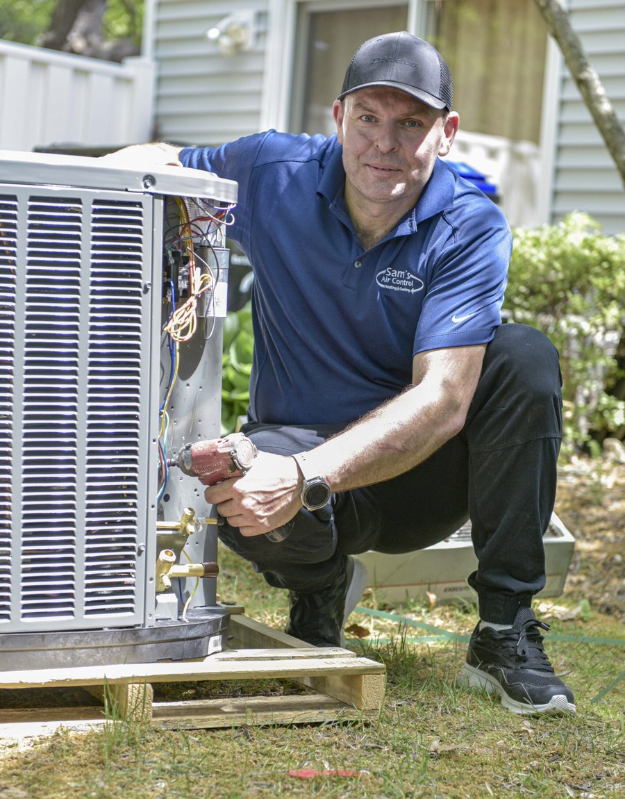 Sam's Air Control technician diagnosing a failing outdoor air conditioning unit